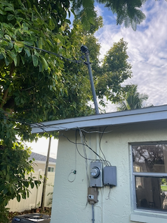 Exterior wall with electric meter and overhead wires