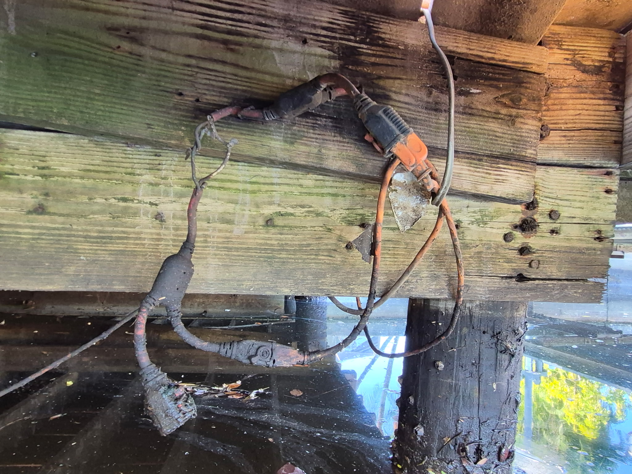 Damaged electrical wires under wooden dock