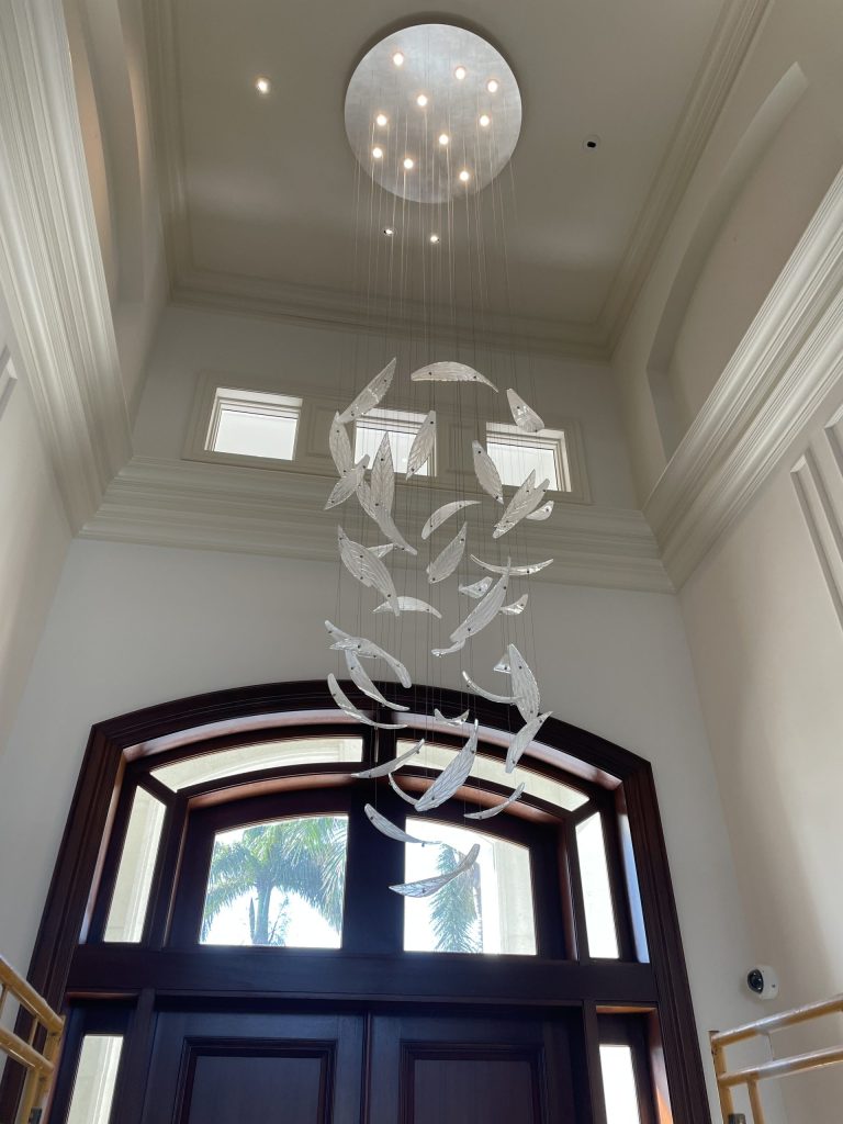 Modern chandelier under arched wooden window ceiling