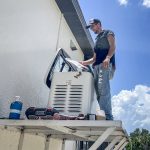 Technician repairing air conditioner outdoors